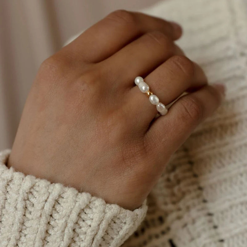 Bague Calypso en perles blanches portée sur une main